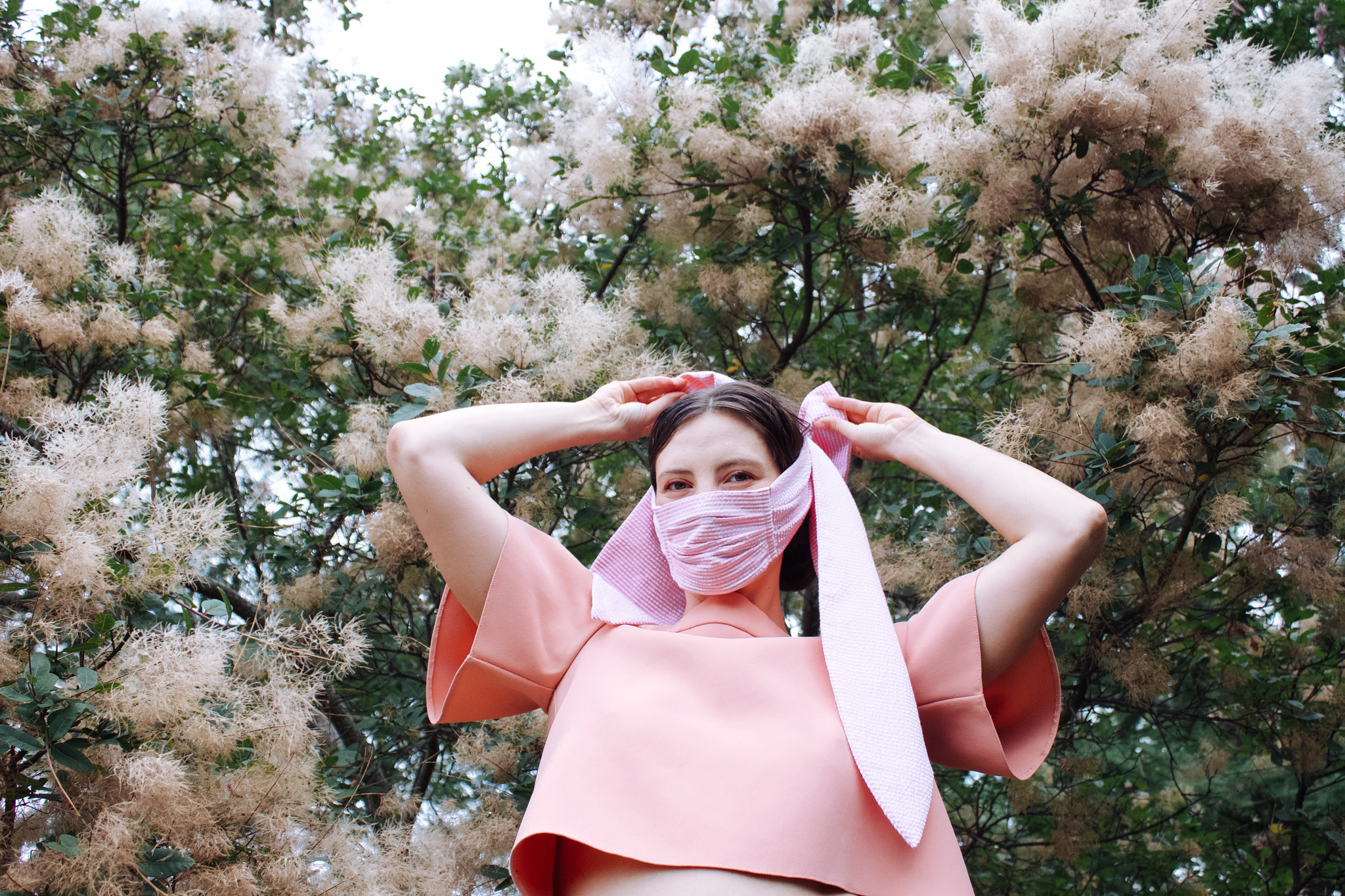 Girl wearing pink shirt and pink face mask with bow