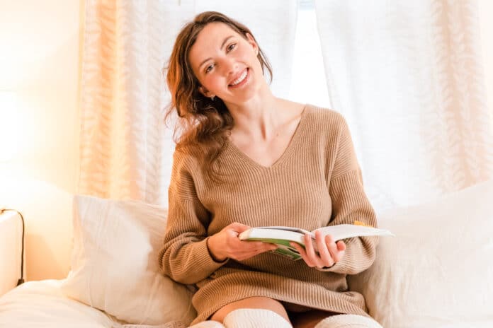 woman-sitting-in-bed-with-book