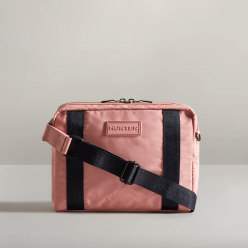 sustainable crossbody bag in light pink with hunter logo on it